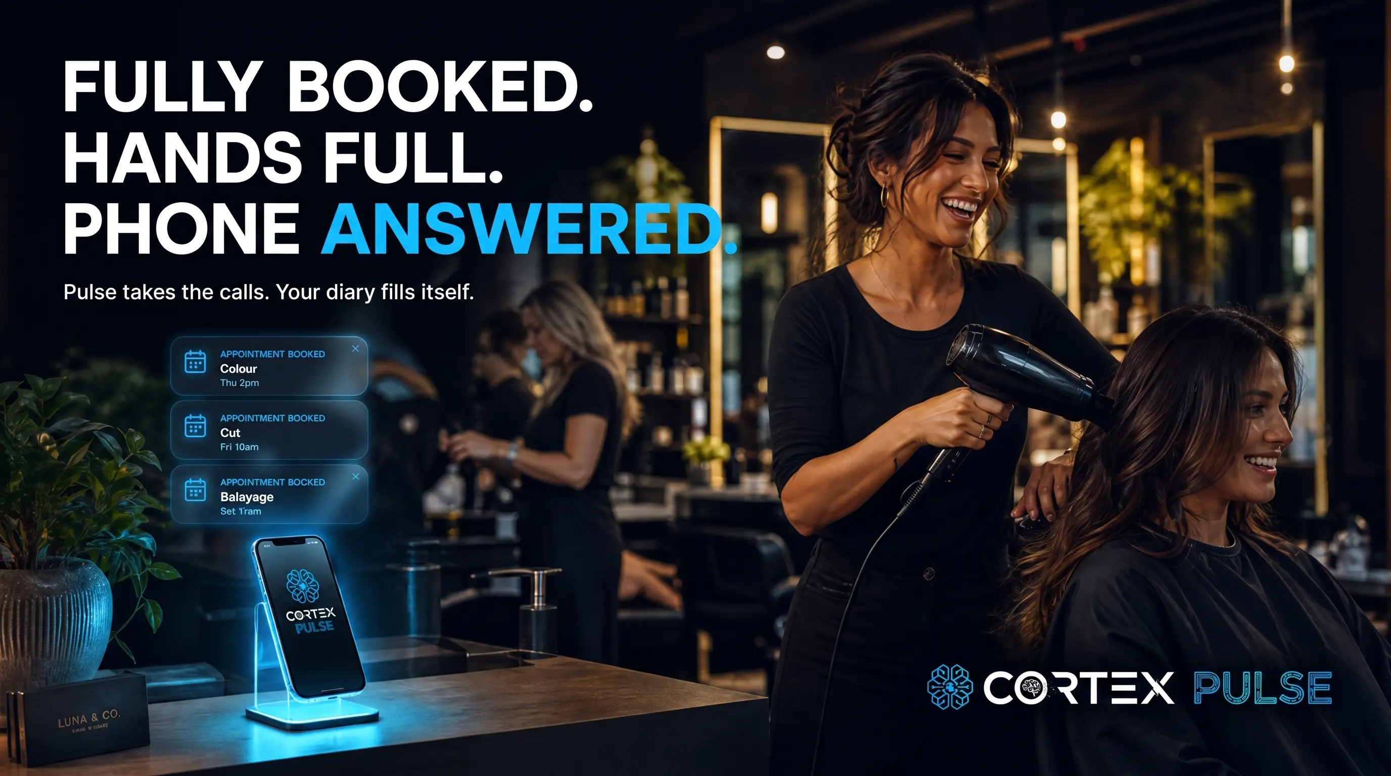 A stylist blow-drying a client in a busy salon while Pulse answers the phone and books colour, cut and balayage straight into the diary — fully booked, hands full, phone answered